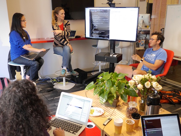 People discussing programming in a fun conference room.