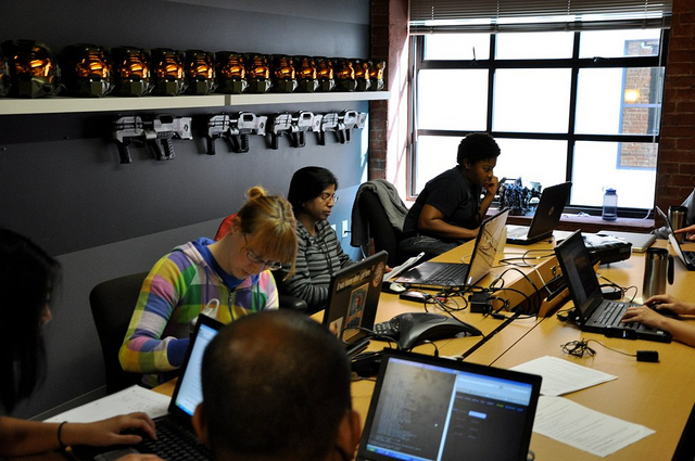 Several people working at computers in a conference room, probably on a Saturday